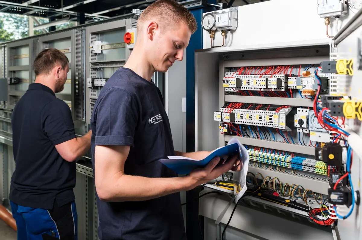 INSTATEC Techniker prüft die Verdrahtung eines MSR-Schaltschranks anhand des Schaltplans